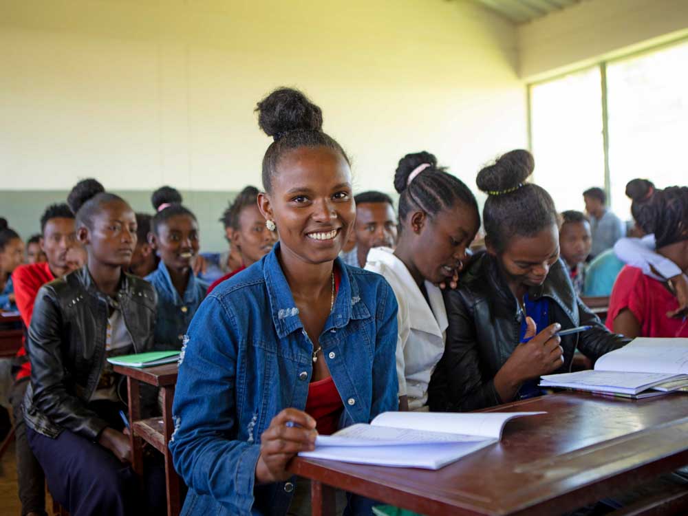 Äthiopisches Mädchen sitzt lächelnd in der Schulklasse