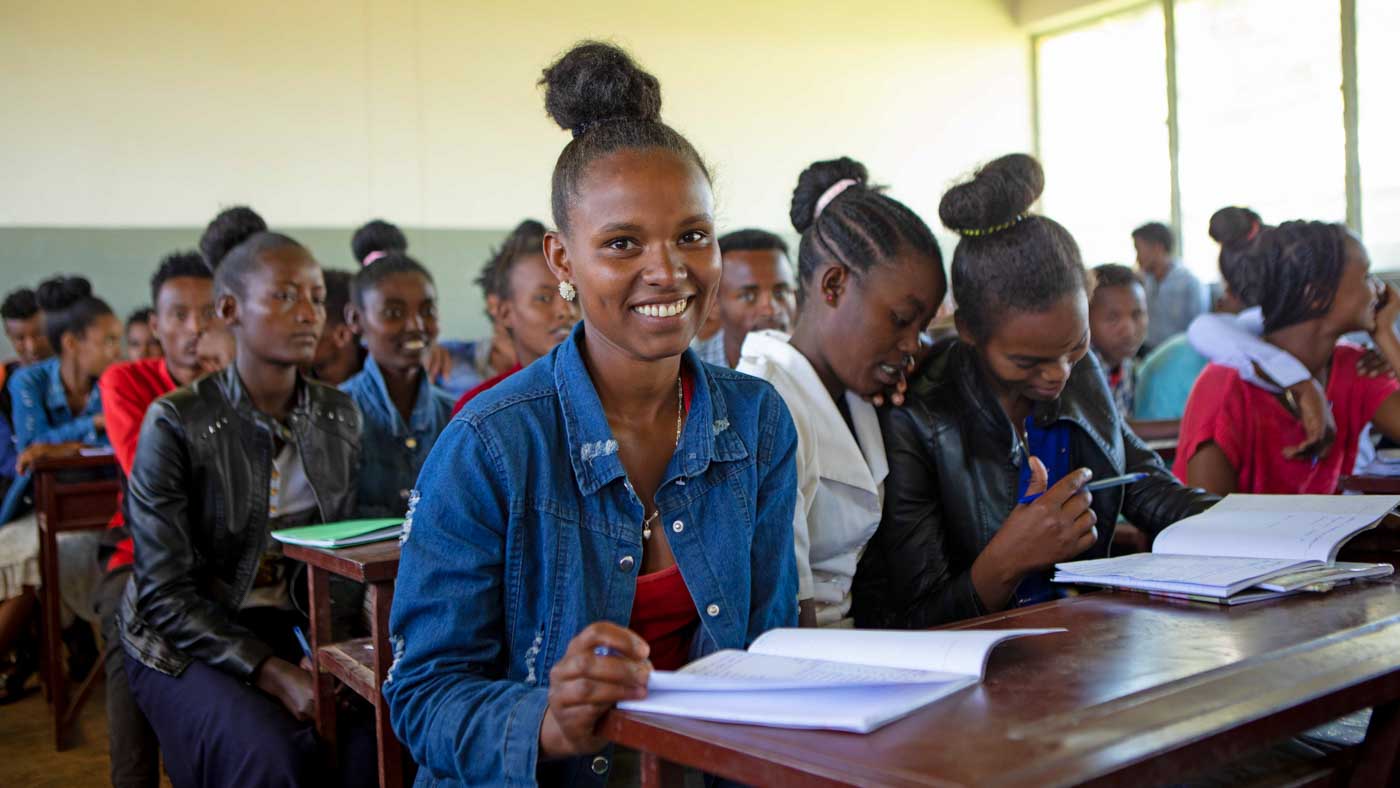 Äthiopisches Mädchen sitzt lächelnd in der Schulklasse
