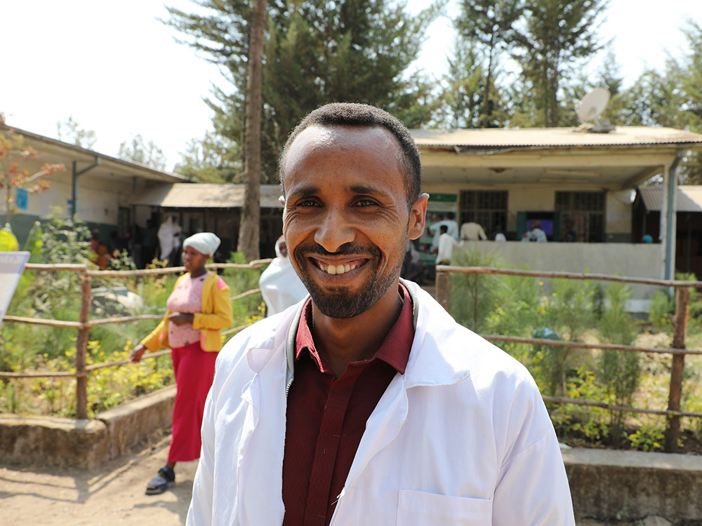 Ein Mann im Arztkittel steht vor einem Gesundheitszentrum in Äthiopien