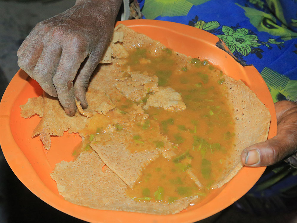 Sauerteigflade (Injera) mit Soße.