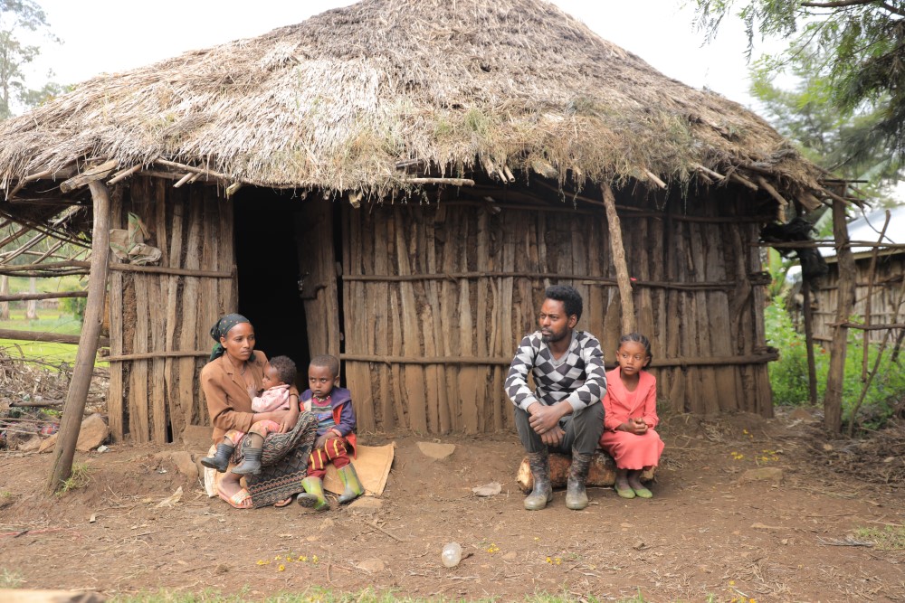 Eine äthiopische Familie sitzt vor ihrer Hütte