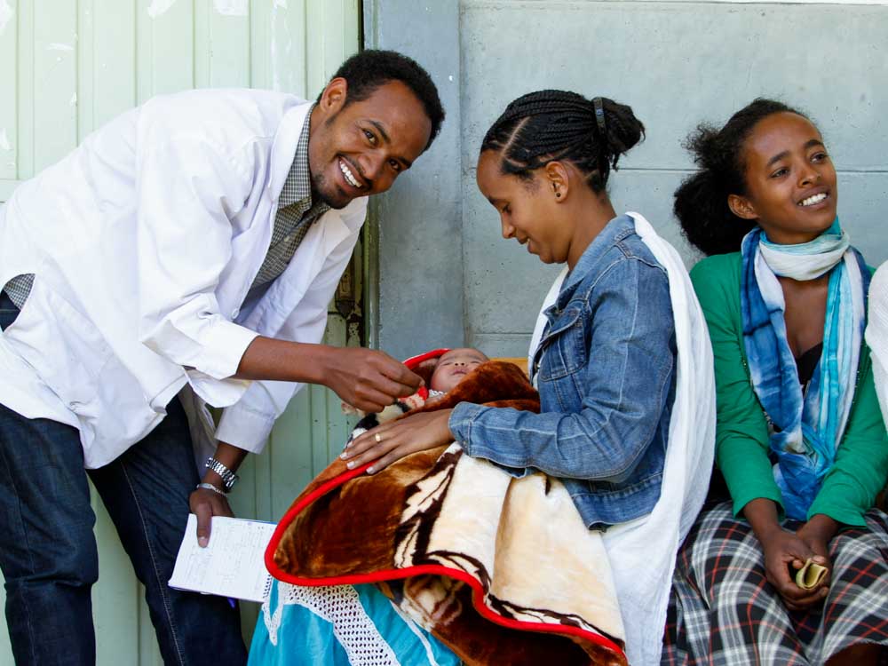 Arzt untersucht Kind, das im Schoss der Mutter liegt in Äthiopien