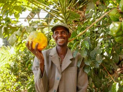 Lächelnder Mann in Äthiopien mit Papaya in der Hand