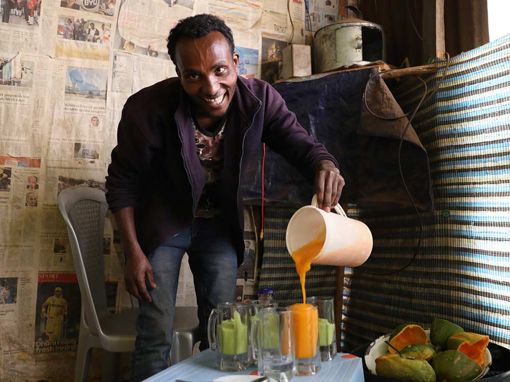 Ein äthiopischer Mann schenkt einen selbstgemachten Smoothie ein