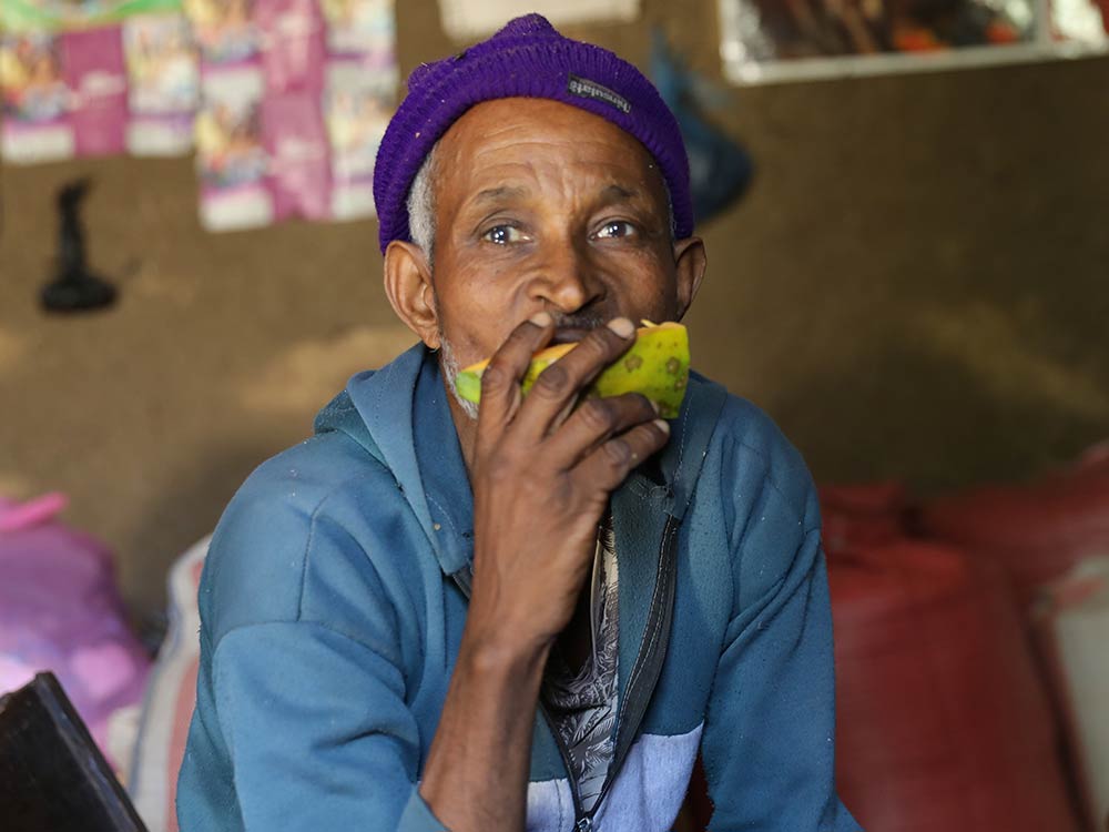 Ein äthiopischer Mann isst eine Frucht