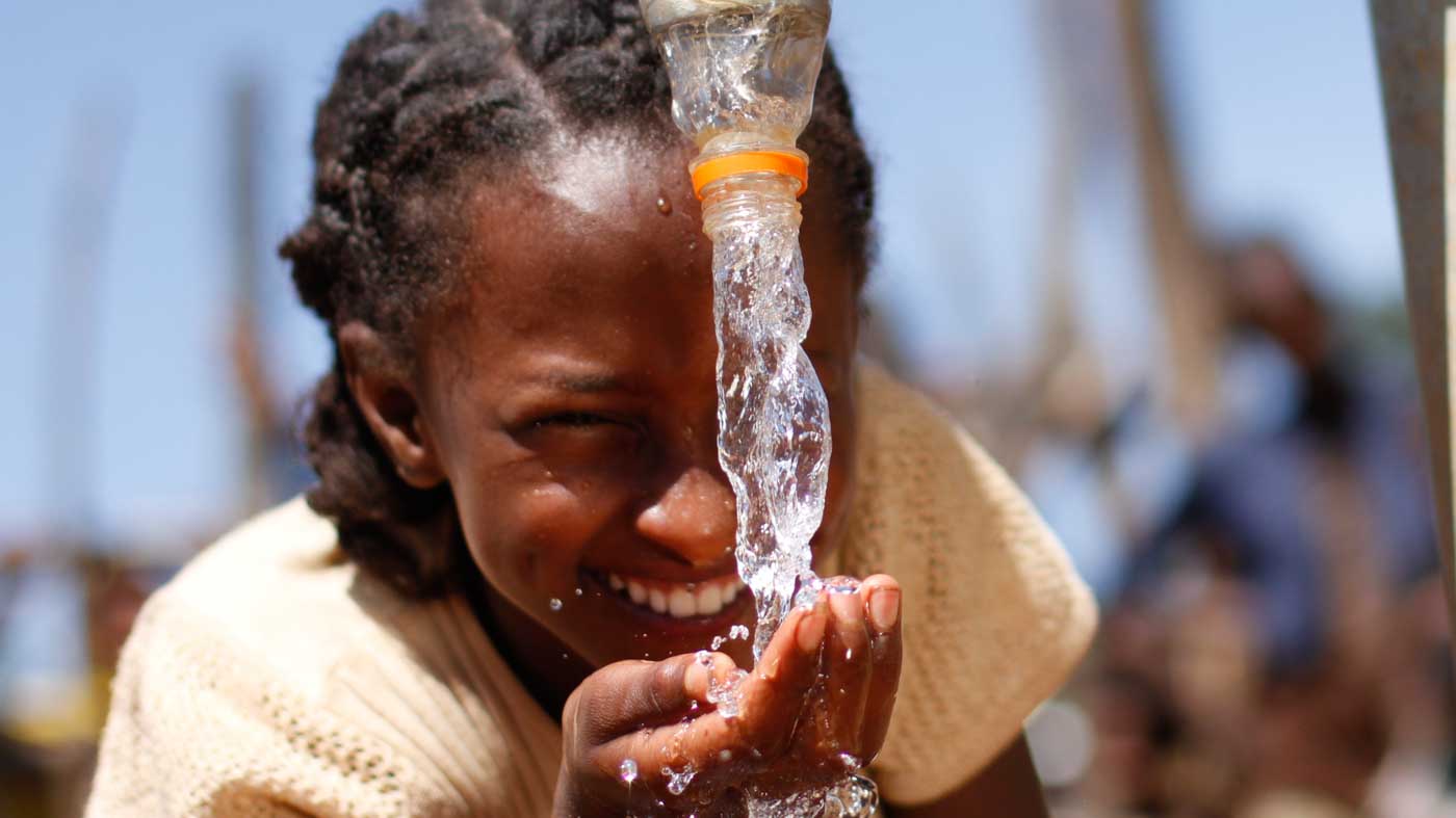 Mädchen in Äthiopien trinkt sauberes Trinkwasser aus einem Brunnen von Menschen für Menschen