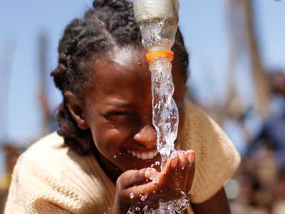 Mädchen in Äthiopien trinkt sauberes Trinkwasser aus einem Brunnen von Menschen für Menschen