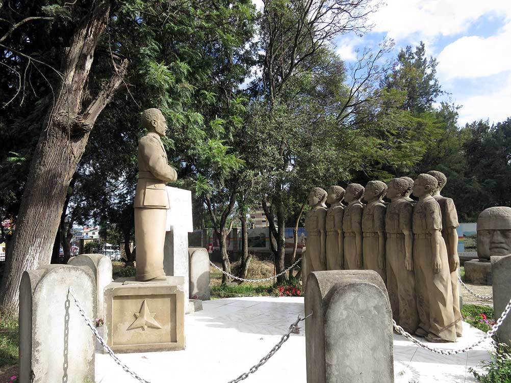Statuen stehen unter einem Baum