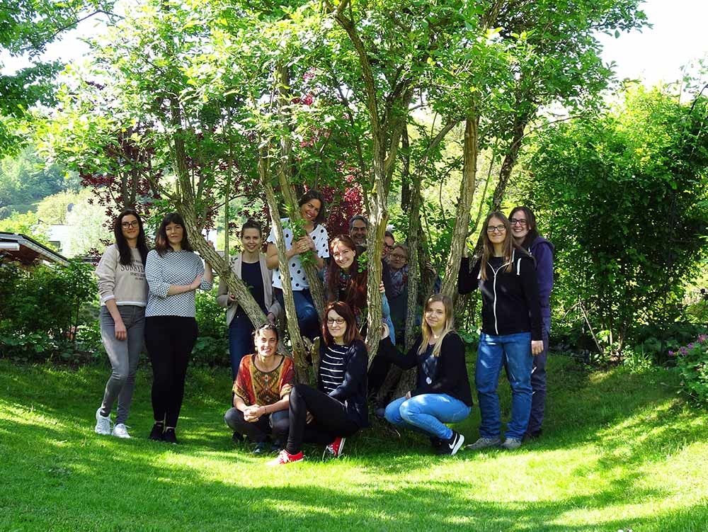 Eine Gruppe Menschen steht unter einem Baum.